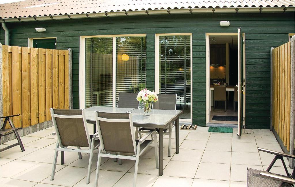 a table with chairs and a vase of flowers on a patio at 1 Bedroom Lovely Home In Retranchement in Retranchement