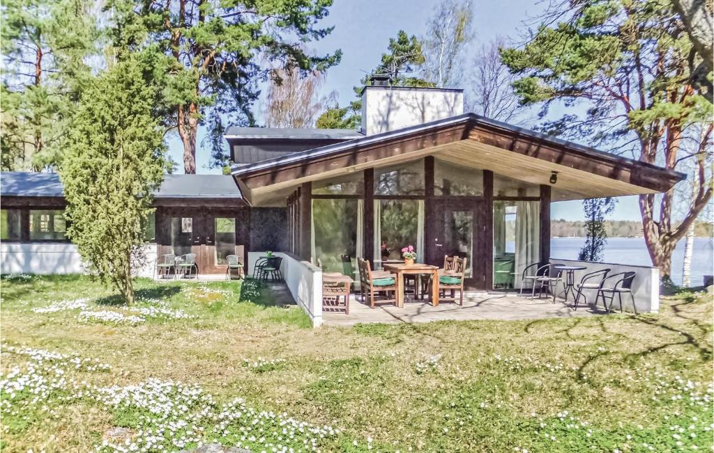 ein kleines Cottage mit einer Terrasse mit einem Tisch und Stühlen in der Unterkunft Amazing Home In Strngns With House Sea View in Aspö