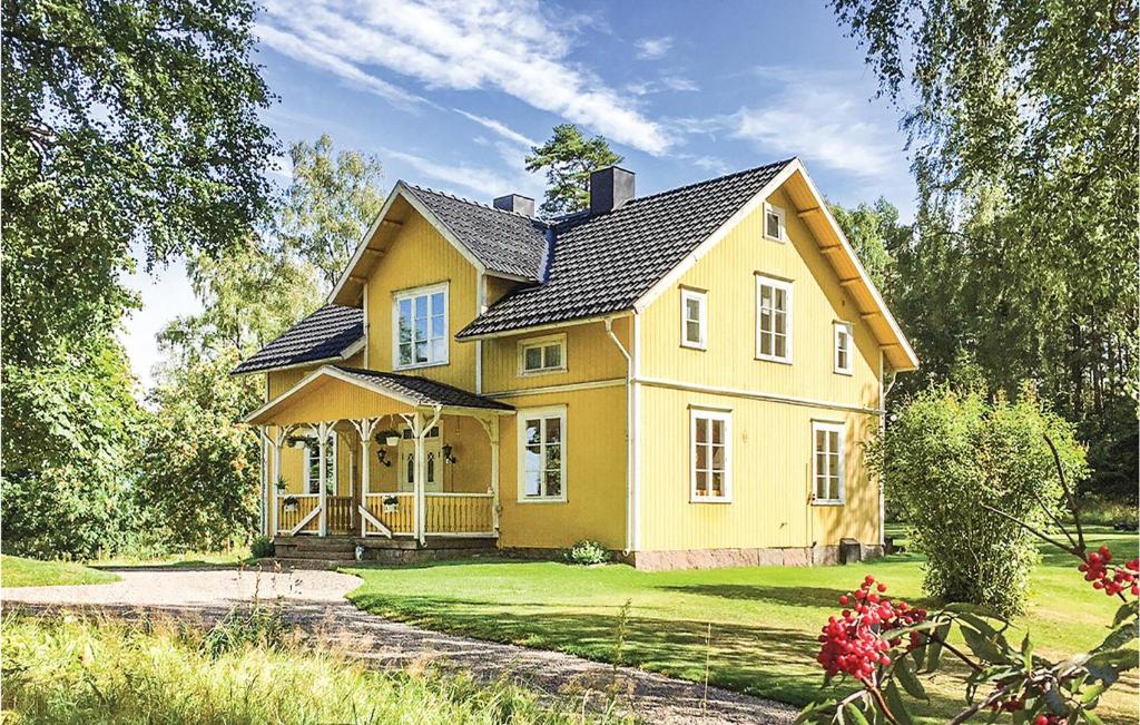 una casa amarilla con techo negro en 4 Bedroom Nice Home In Mullsj en Mullsjö