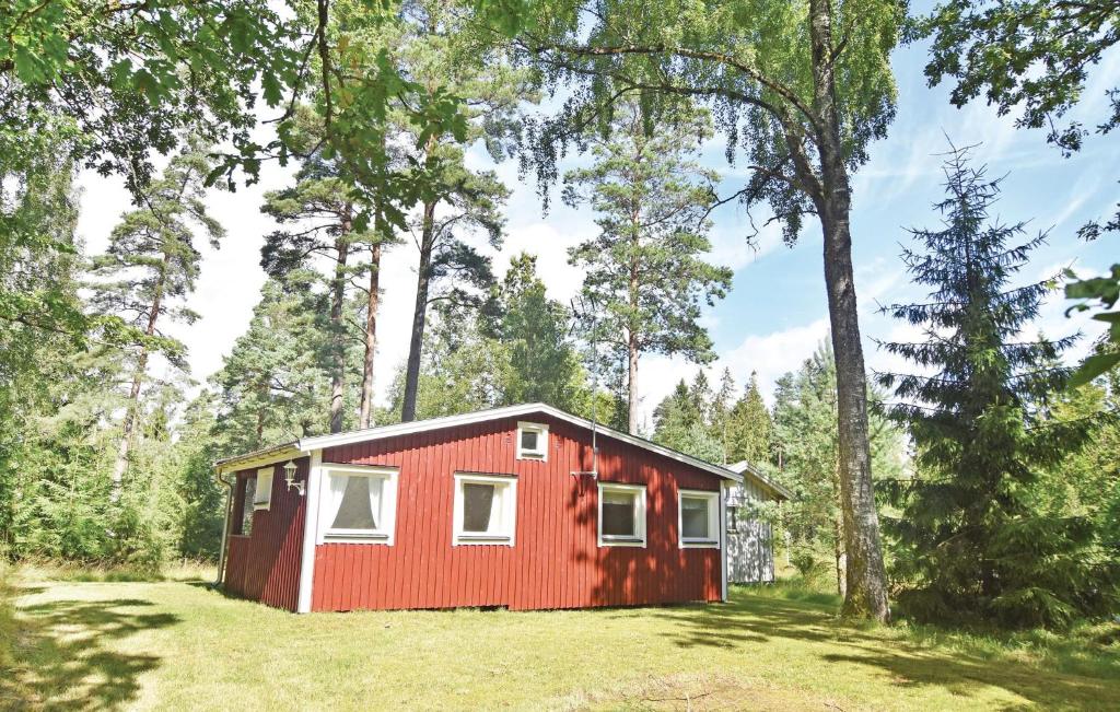 a red cabin in the middle of a forest at 1 Bedroom Amazing Home In Stenkullen in Stenkullen