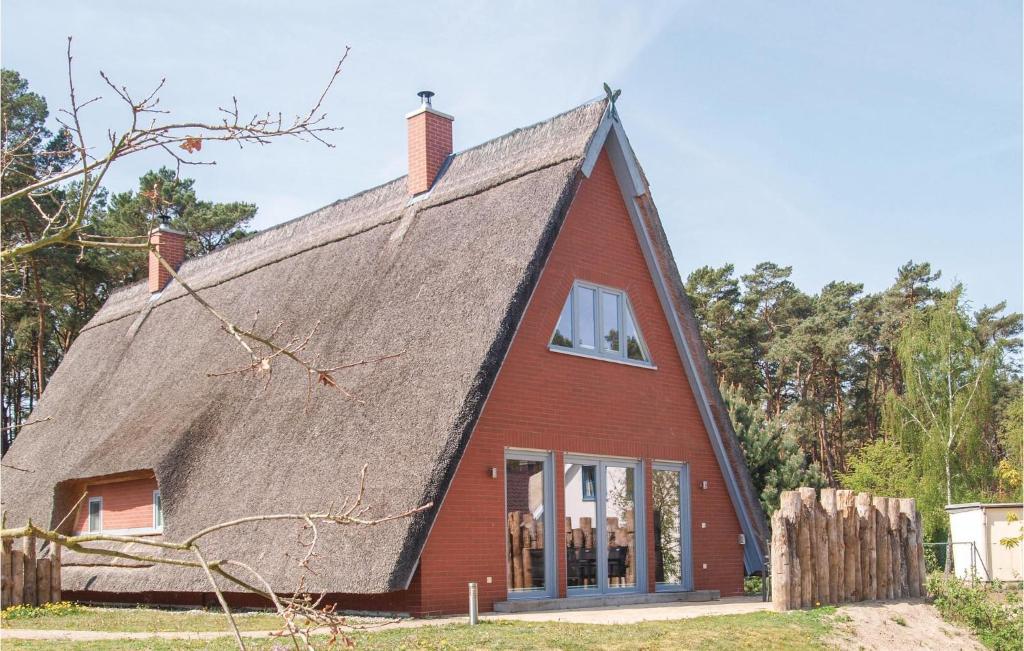 a red house with a thatched roof at Awesome Home In Loddin With 2 Bedrooms, Sauna And Wifi in Loddin