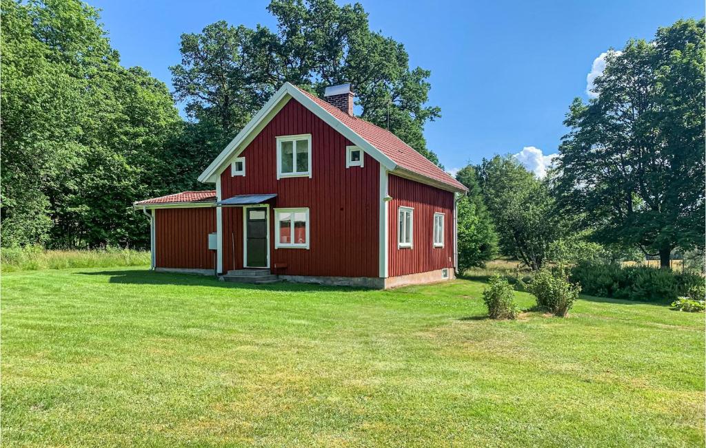 une grange rouge dans un champ d'herbe dans l'établissement Beautiful Home In Sjtofta With Kitchen, à Hornbetan