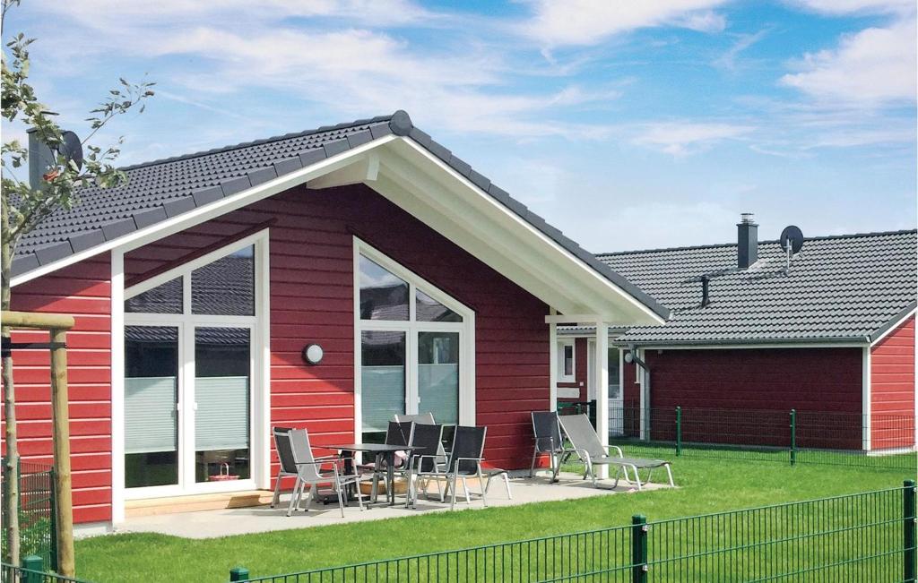 ein rotes Haus mit Stühlen und einem Tisch davor in der Unterkunft Nice Home In Dagebll With 2 Bedrooms, Sauna And Wifi in Dagebüll