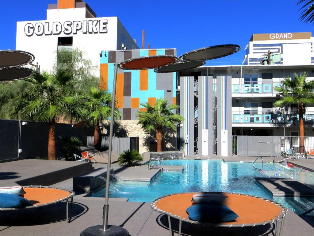 a swimming pool with tables and umbrellas on a building at Oasis at Gold Spike - Adults Only in Las Vegas