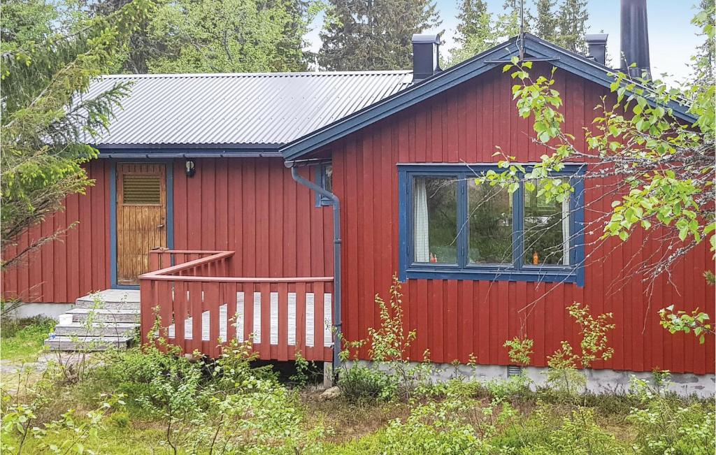 a red cabin with a blue window and a porch at Nice Home In Slen With Wifi in Våtkölssätern