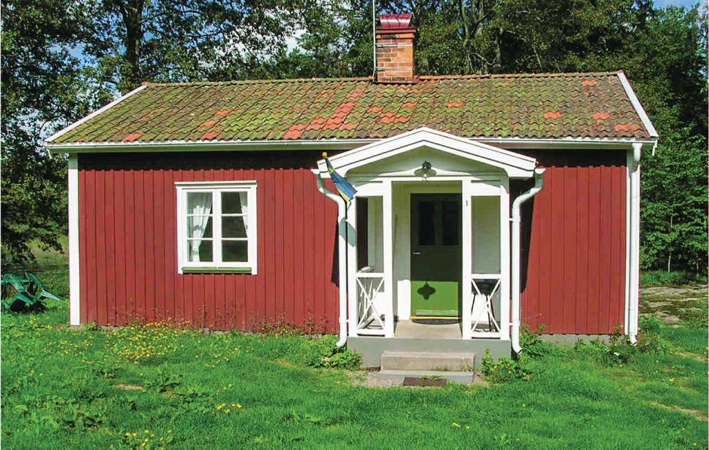 un cobertizo rojo y blanco con una puerta blanca en 1 Bedroom Cozy Home In Vimmerby, en Vimmerby