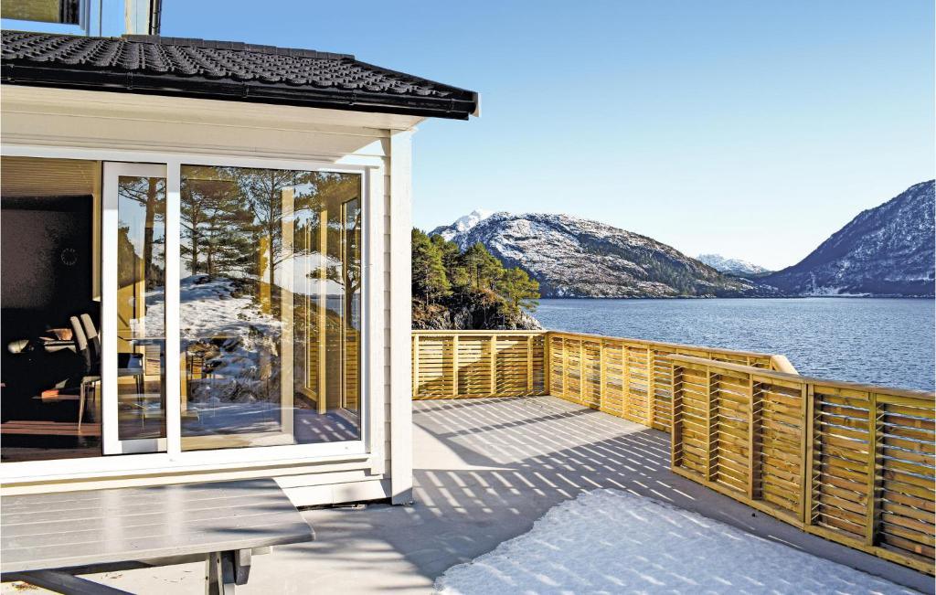 a house with a balcony with a view of the water at Lovely Home In Flor With Wifi in Florø