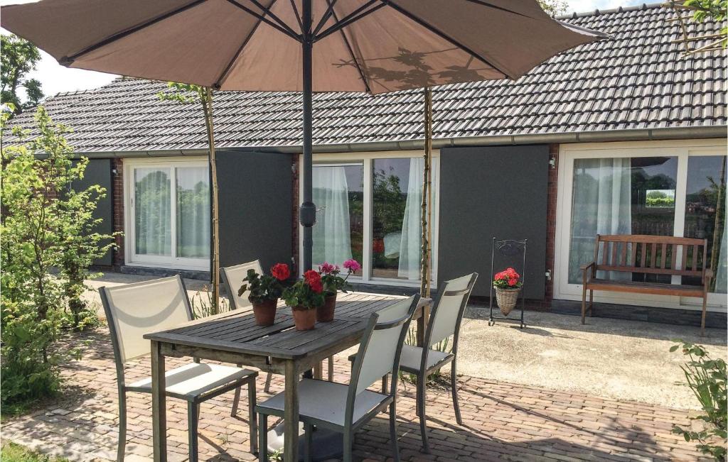 een tafel en stoelen met een parasol op een patio bij Boszicht in Baarle-Nassau