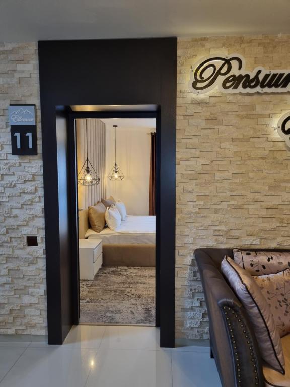 una camera d'albergo con letto e specchio di Pensiunea Ellemar a Vatra Dornei