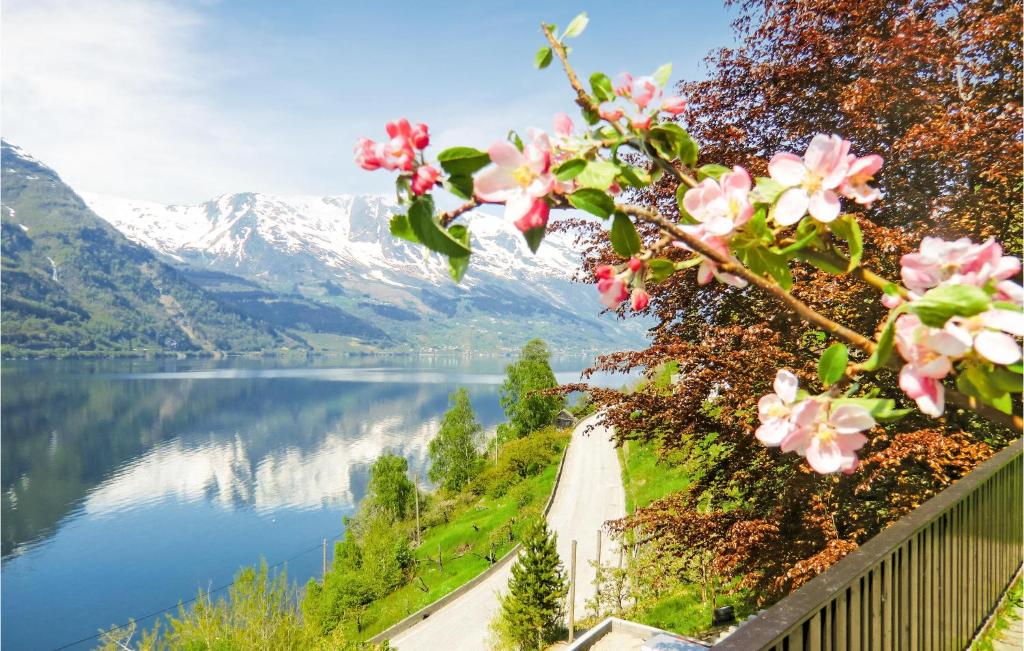a view of a lake and mountains with pink flowers at Gorgeous Home In Hovland With Wifi in Espe