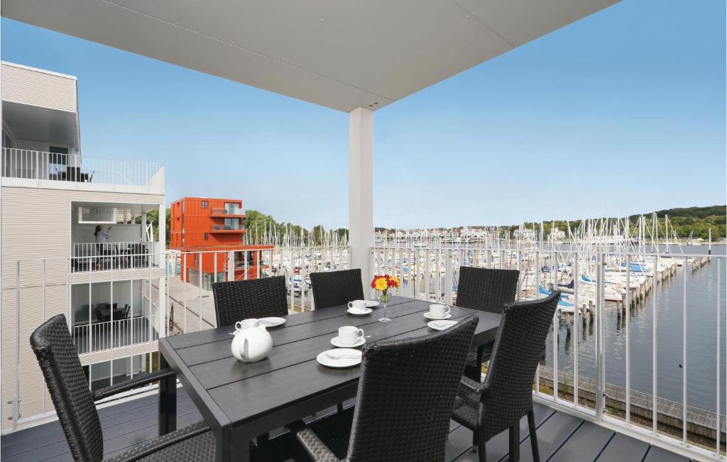 a dining table on a balcony with a view of a marina at Promenadenvilla in Priwall