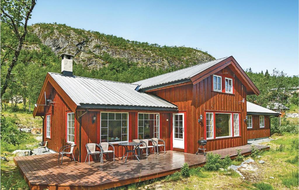 a wooden cabin with a deck and chairs on it at Skarsnuten in Hemsedal