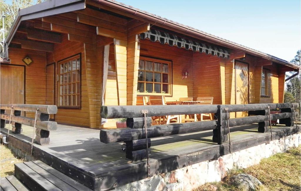 uma cabana de madeira com um grande deque à sua frente em Beautiful Home In Grisslehamn With Kitchen em Grisslehamn
