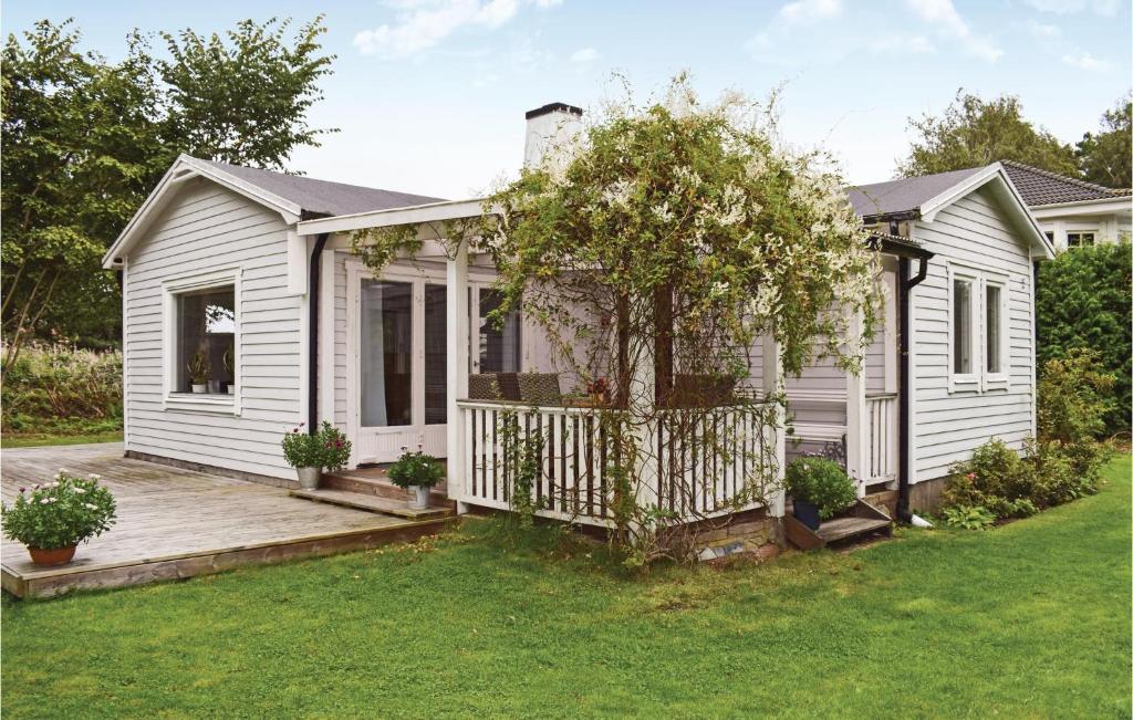 Casa blanca con terraza de madera en el patio en Beautiful Home In Jonstorp With Kitchen, en Jonstorp