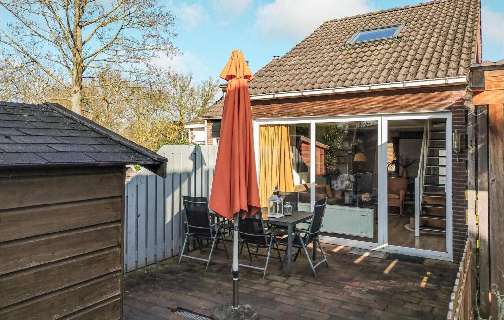 een patio met een tafel en een parasol bij Bungalowpark De Tong in Bruinisse