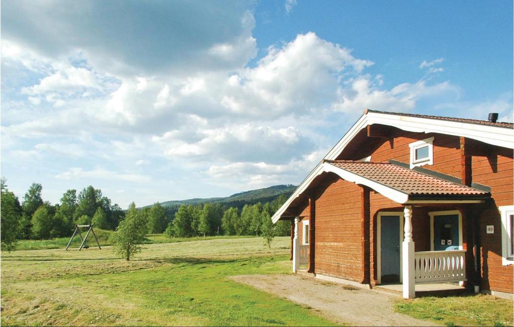 a small wooden house with a porch in a field at Cozy Home In Sysslebck With Kitchen in Branäs