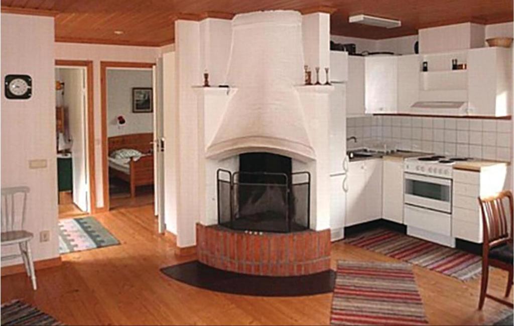 a kitchen with a fireplace in the middle of a room at Cozy Home In Eksj With Kitchen in Eksjö