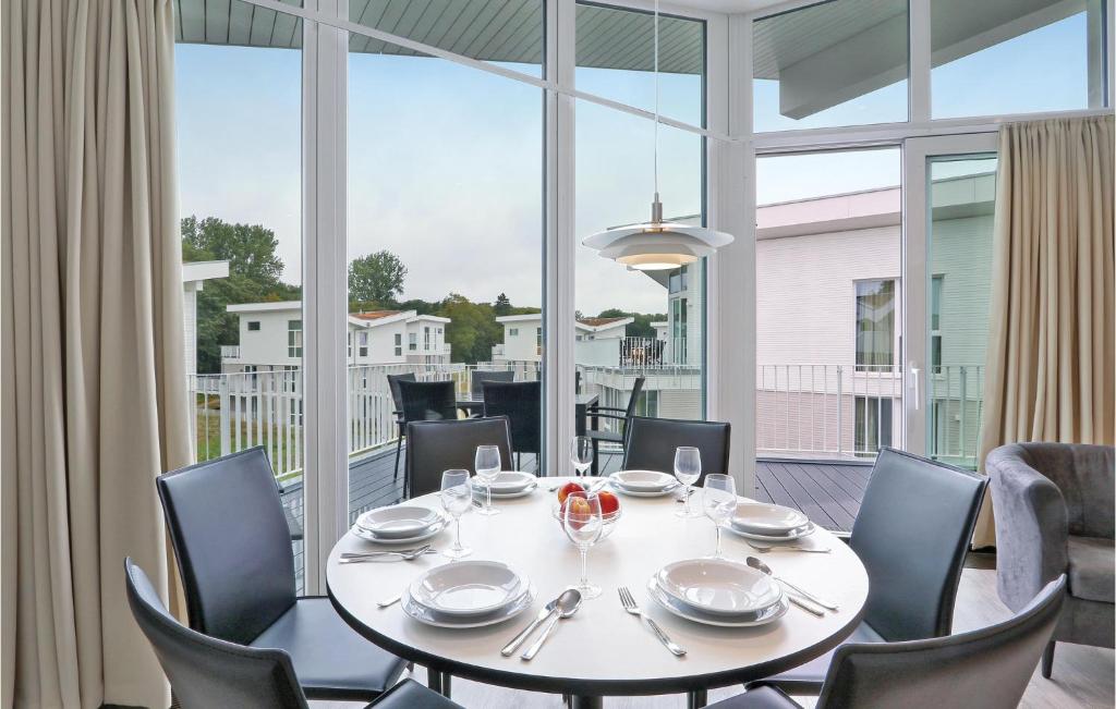 une salle à manger avec une table, des chaises et une grande fenêtre dans l'établissement Dnenvilla Penthouse Deluxe, à Travemünde