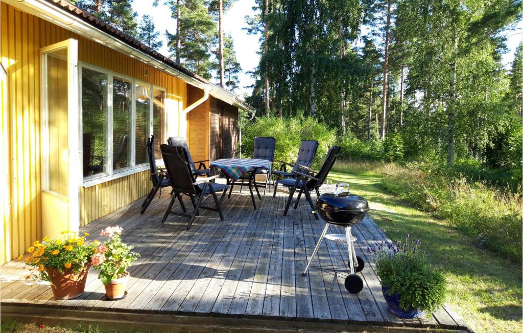 une terrasse avec un grill et des chaises sur une maison dans l'établissement 3 Bedroom Nice Home In Kisa, à Kisa