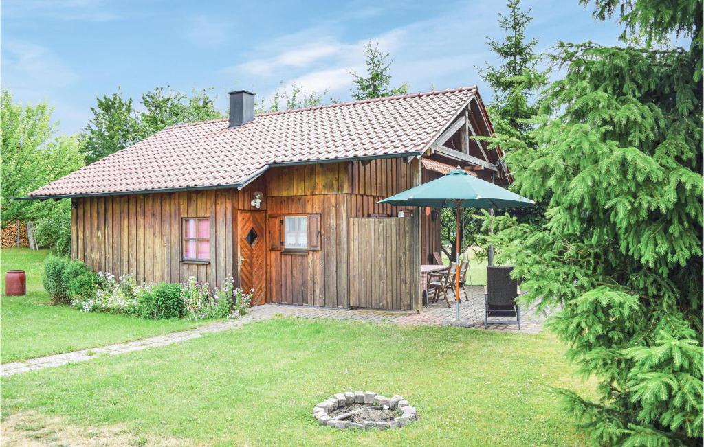 a wooden cabin with a table and an umbrella at Awesome Home In Waldmnchen With 3 Bedrooms And Wifi in Kleinschönthal