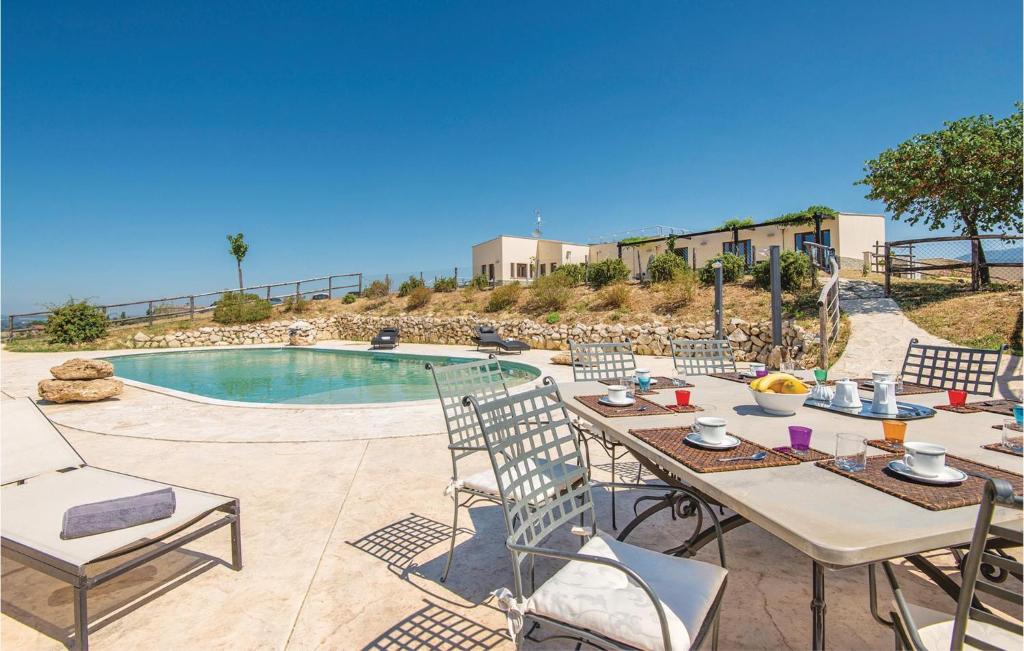 un patio con mesa y sillas junto a una piscina en Blue Cherry, en Collevecchio