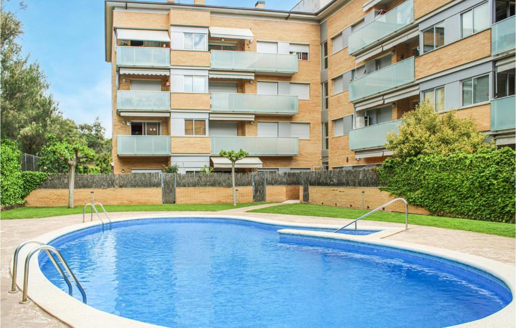 a swimming pool in front of a building at Stunning Apartment In Tossa De Mar With Kitchen in Tossa de Mar