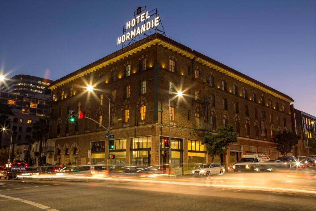 a building with a sign on top of it at night at Hotel Normandie - Los Angeles in Los Angeles