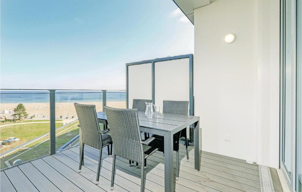 een eettafel en stoelen op een balkon met uitzicht op het strand bij Awesome Apartment In Lbeck Travemnde With House Sea View in Travemünde