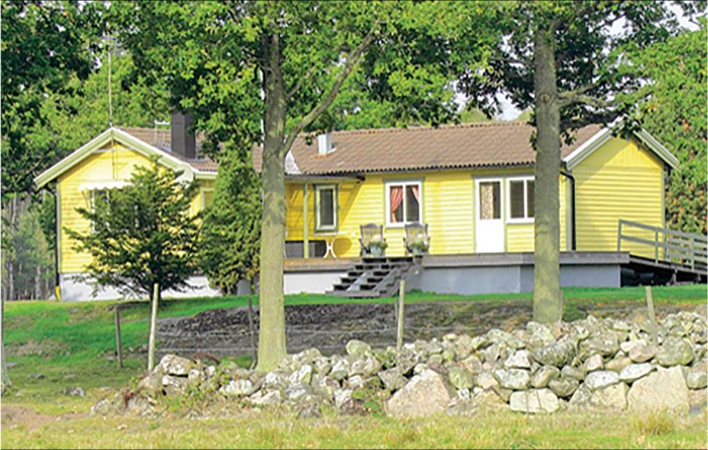 una casa amarilla delante de una casa en Nice Home In Jmj With House Sea View, en Torhamn