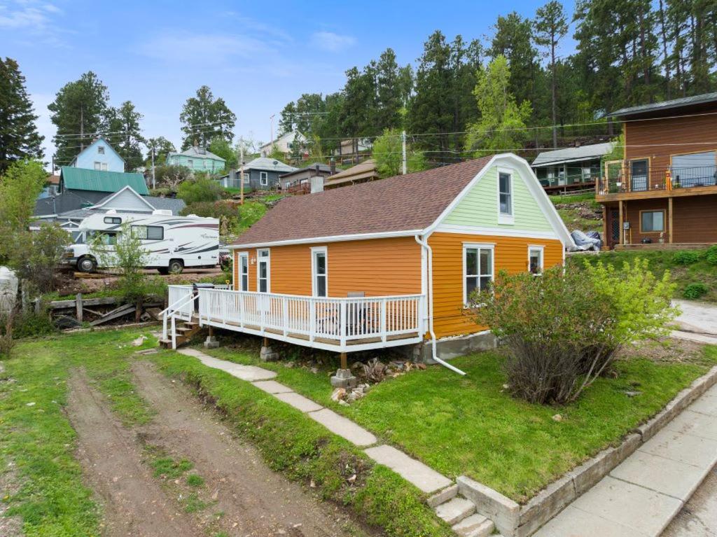 a yellow and orange house in a residential neighborhood at The Overlook Nook in Lead