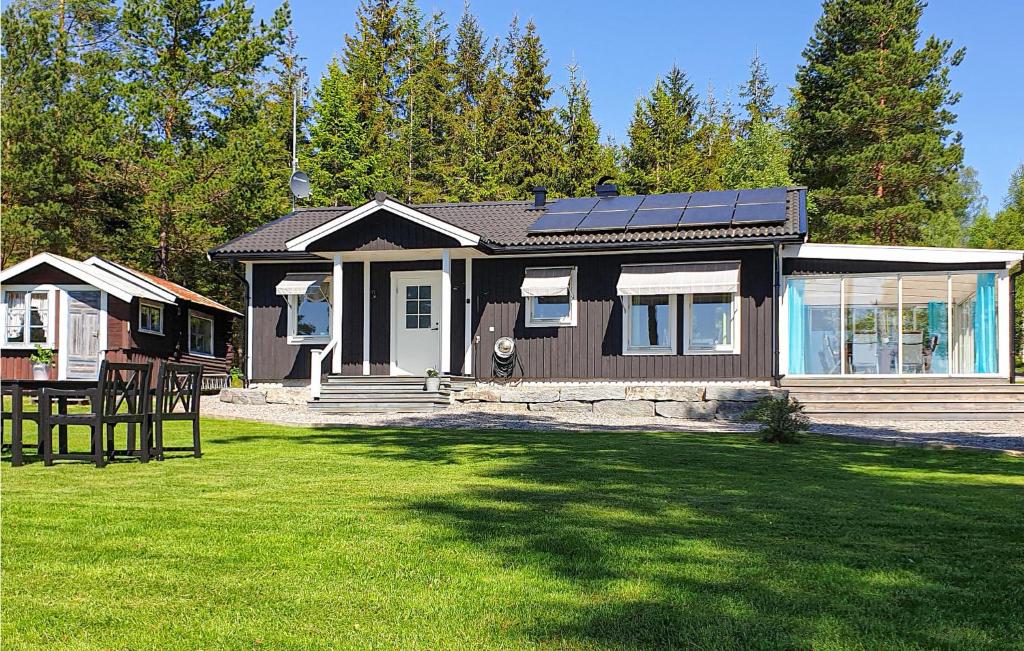 a small house with solar panels on top of a yard at Lovely Home In rjng With Kitchen in Gyltenäs