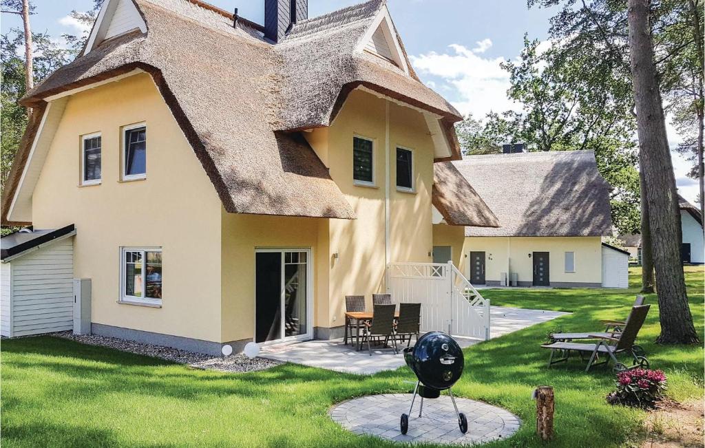 una casa con tetto di paglia e una statua in cortile di Reetdachhaus Kiek In` Wald a Kutzow