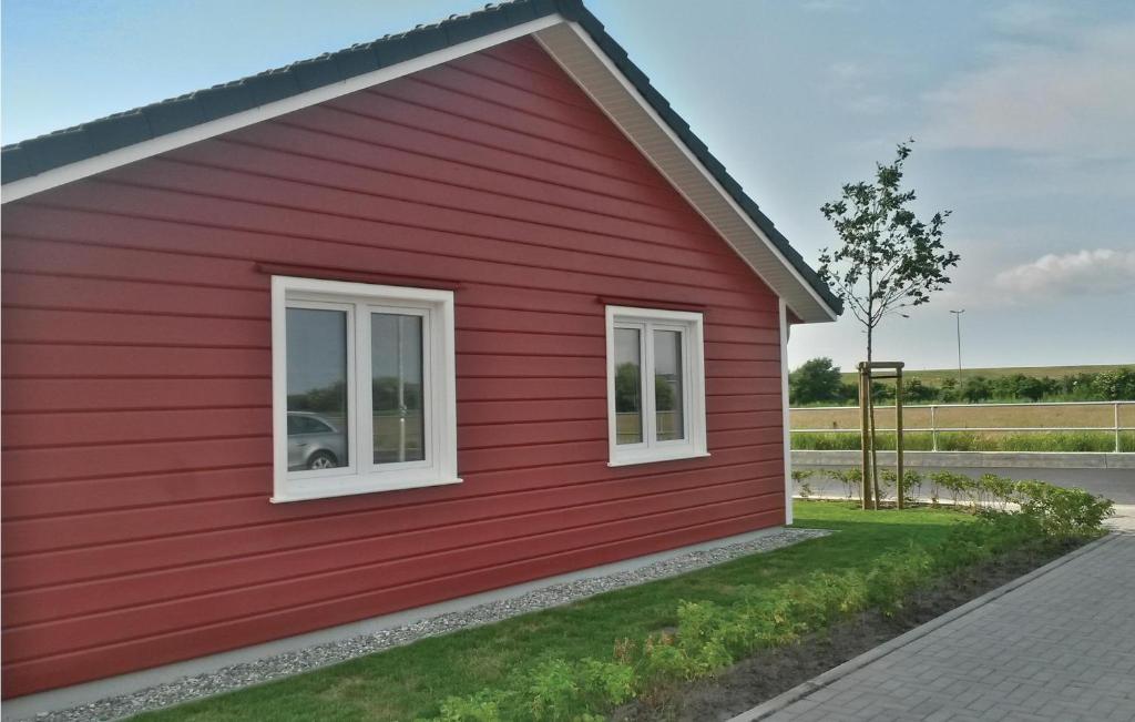 een rood huis met witte ramen aan de zijkant bij 2 Bedroom Cozy Home In Dagebll in Dagebüll