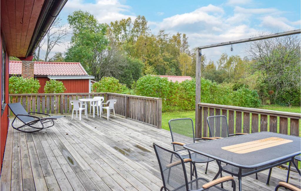 シーピンスリーにあるBeautiful Home In Kpingsvik With 2 Bedroomsのパティオ(テーブル、木製デッキの椅子付)