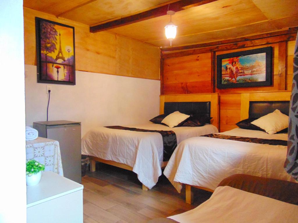 um quarto de hotel com duas camas com paredes de madeira em Room in Guest room - Nice Quadruple Cabin Equipped And Very Central em Zacatlán
