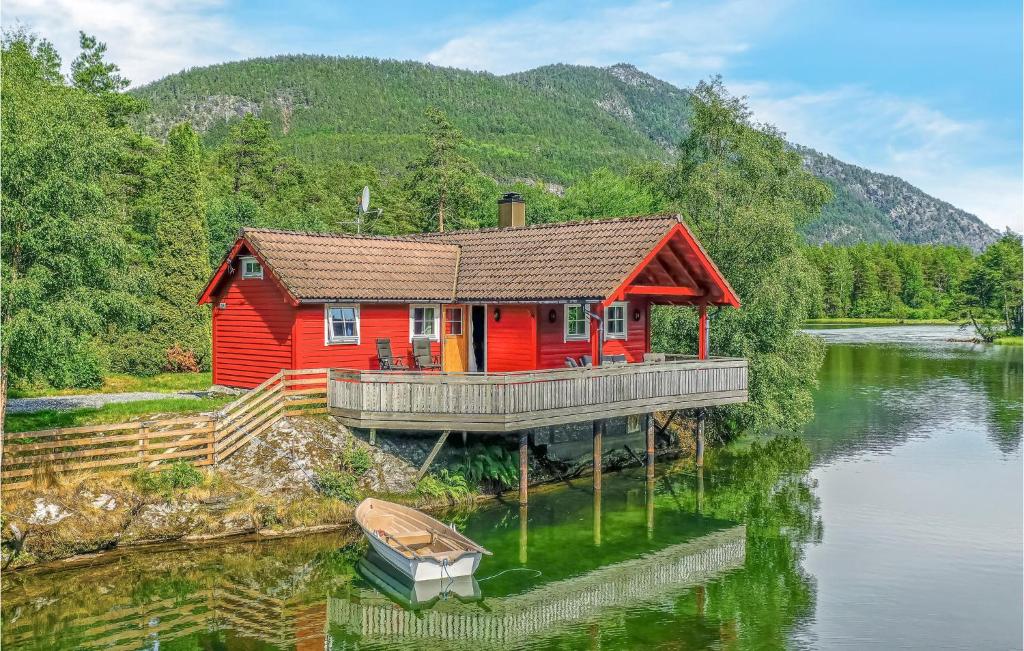 a red house on a dock on a lake at 3 Bedroom Amazing Home In Sandane in Sandane