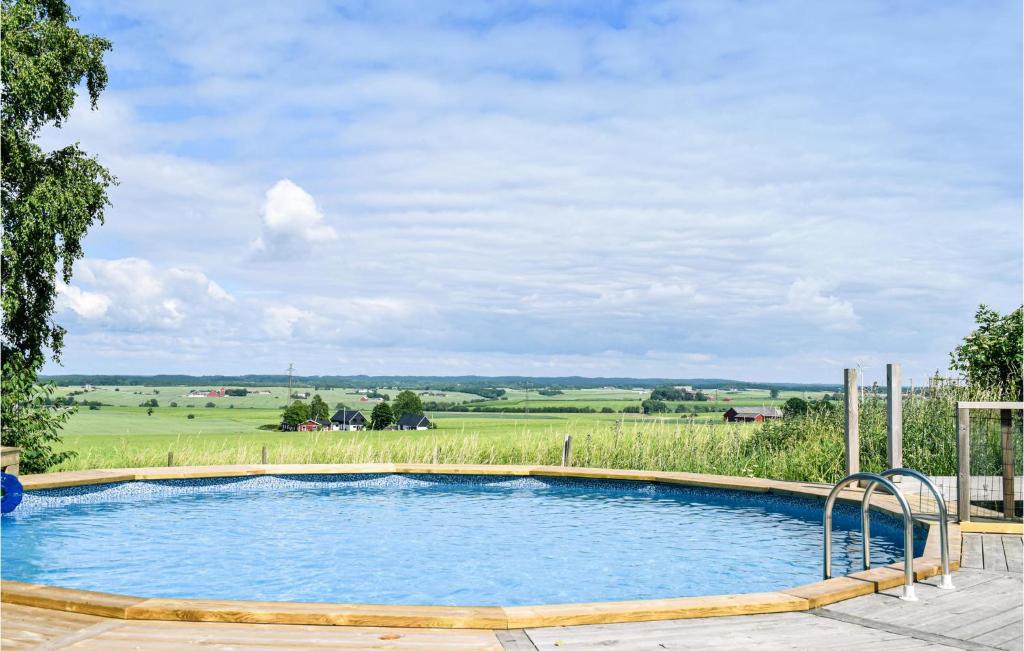 a swimming pool with a view of a field at Lovely Home In ngelholm With Outdoor Swimming Pool in Ängelholm