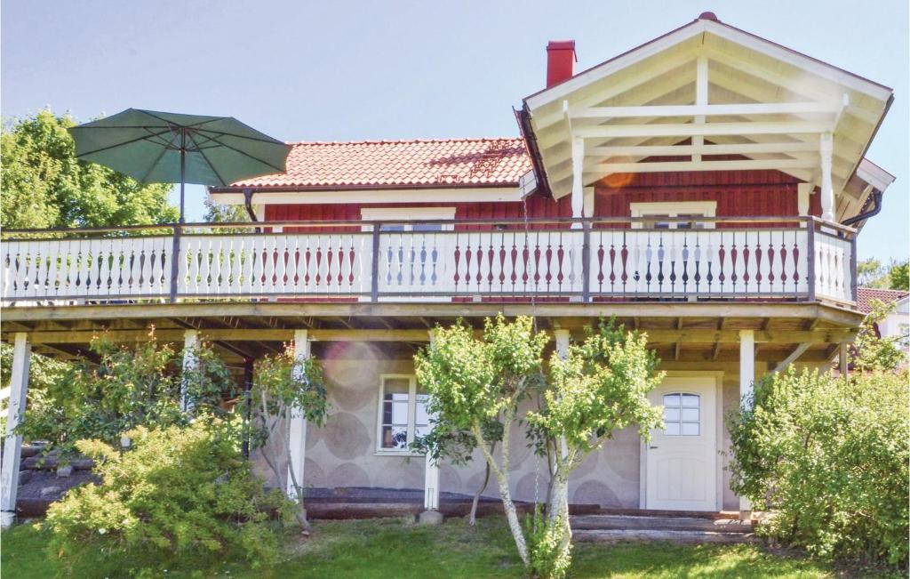 ein großes Haus mit Balkon und Sonnenschirm in der Unterkunft Stunning Home In Svanskog With 3 Bedrooms And Wifi in Svanskog