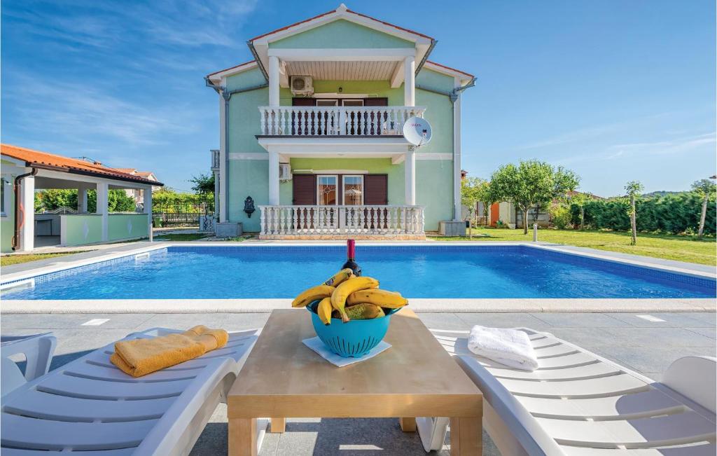 a bowl of bananas on a table next to a pool at Stunning Home In Kapelica With Wifi in Raša