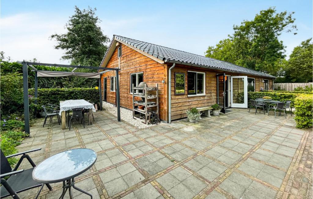 een houten huisje met een patio met een tafel en stoelen bij Gorgeous Home In Loosdrecht With Kitchen in Loosdrecht