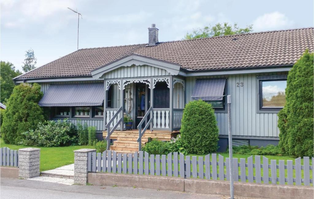 a house with a white fence in front of it at 3 Bedroom Cozy Home In Vimmerby in Vimmerby