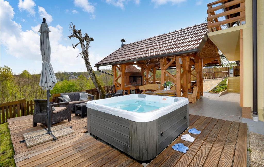 a hot tub on a deck next to a house at Gorgeous Home In Siljakovina With Jacuzzi in Šiljakovina