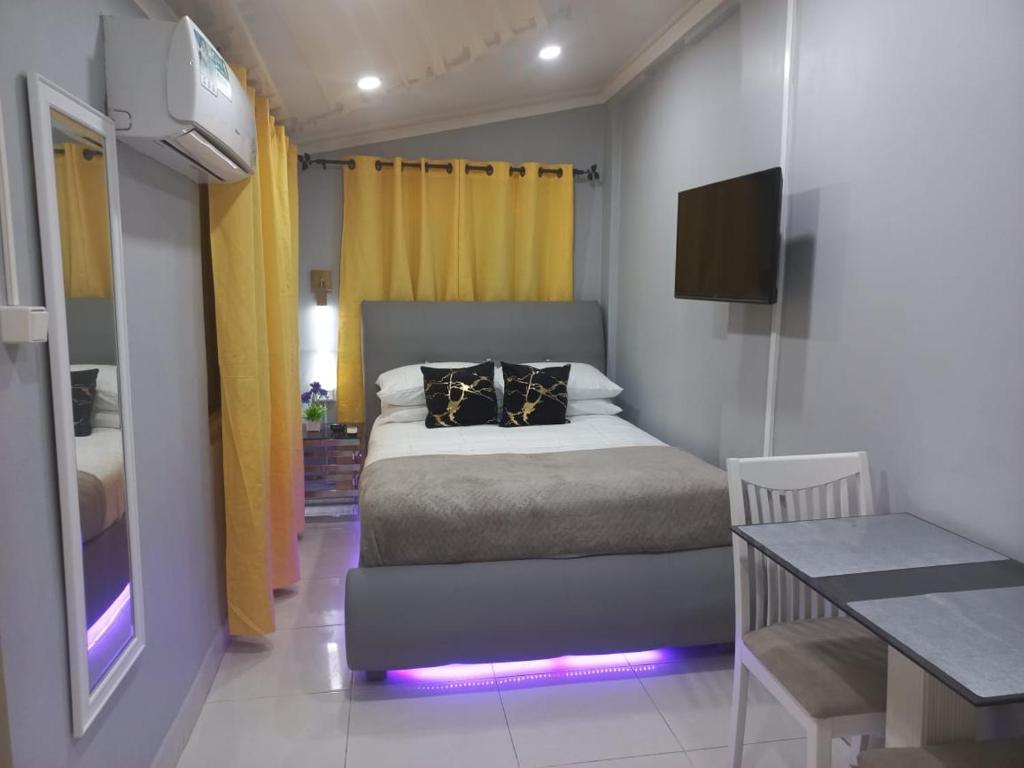 um quarto com uma cama, uma mesa e uma televisão em The Brayan's Apartment em Oranjestad
