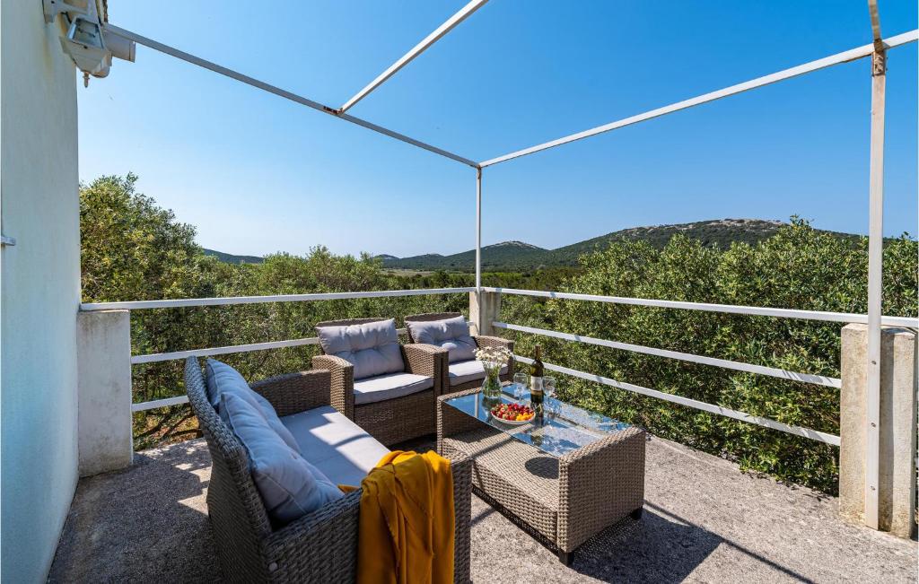 a balcony with chairs and a table with a view at 2 Bedroom Nice Home In Molat in Molat