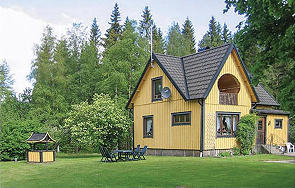 una casa amarilla con cenador en un patio en 3 Bedroom Awesome Home In lmhult, en Älmhult
