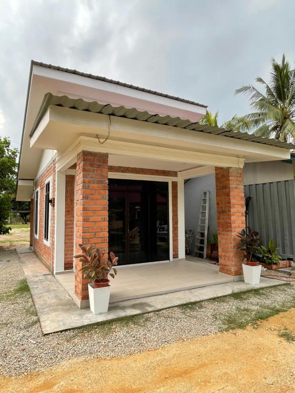 a small house with a porch at Cabin in the Woods by Abris in Bukit Gambir