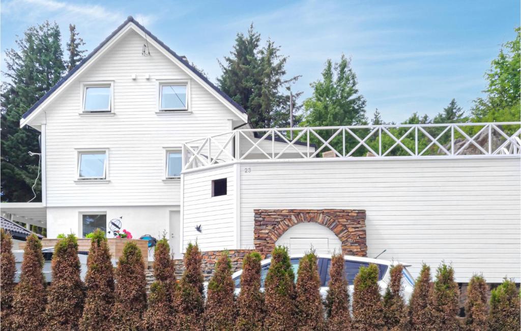 a white house with an arbor over a garage at Amazing Apartment In Fjell in Lokøy