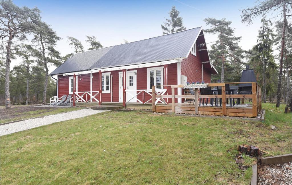 un granero rojo con una valla en un campo en Pet Friendly Home In Visby With Kitchen, en Endre