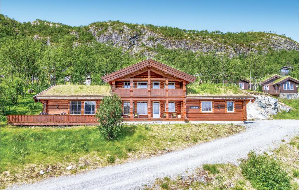 a log cabin with a grass roof on a dirt road at Skarsnuten in Hemsedal