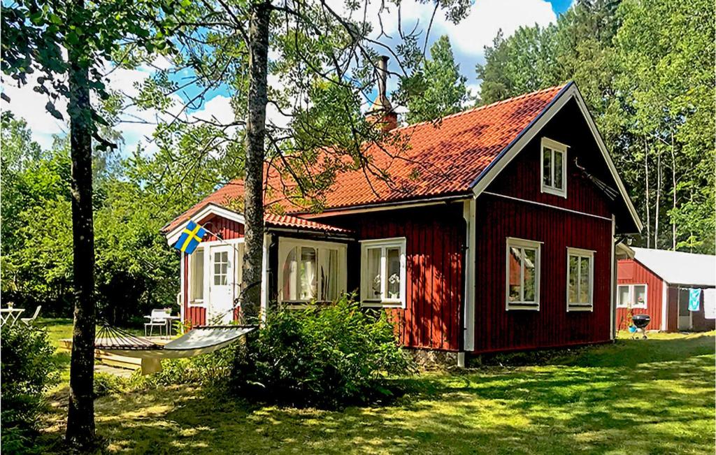 una pequeña casa roja con techo rojo en Amazing Home In Hultsfred With 3 Bedrooms, en Skinshult